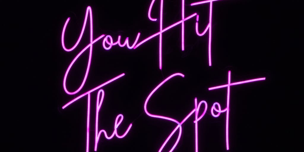 Close-up of a poster covered in cheap vinyl stickers that form a dense word cloud of clickbait and SEO keywords (e.g., 'viral', 'free', 'how to', 'best'). A neon dollar sign sticker is slapped over the center; the surface looks tacky and crowded, visually representing spammy, low-cost AI-generated content optimized only for clicks.