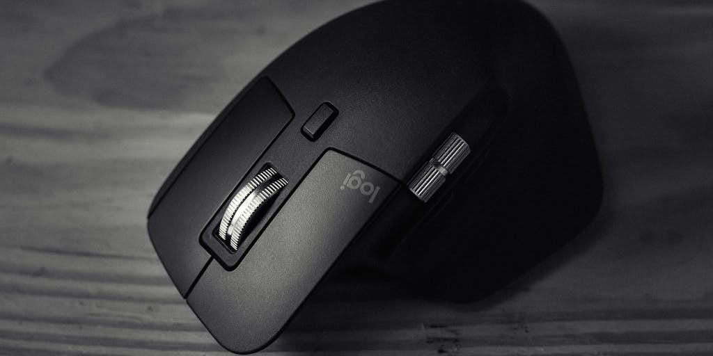 Minimalist desktop shot: an uncluttered workspace with a laptop closed, a cup of coffee, and in the center of the frame a floating digital answer card (plain text and small icon) hovering above the desk. A computer mouse sits nearby with a translucent cursor icon hovering and a subtle red slash through it to symbolize 'no click.' High-contrast, editorial lighting and negative space create a clean visual metaphor for instant answers without interaction.