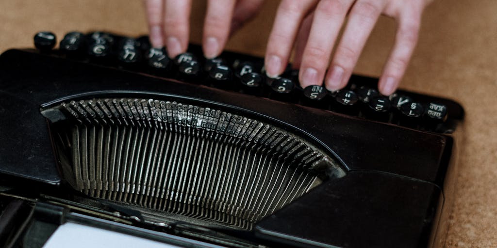 Close-up, cinematic macro of a brushed-steel robotic hand typing on a vintage typewriter, with a sleek laptop in the blurred background showing a modern content scorecard and backlink graph. The composition blends analog craftsmanship with cutting-edge AI SEO tools, using shallow depth of field and warm film tones to create a poetic contrast between past and future writing tools.