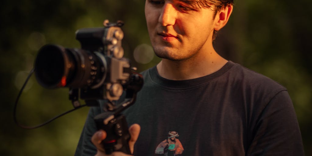 Hands-on unboxing and review setup: close-up of hands opening an Amazon shipping box with the product partially visible, a mirrorless camera on a tripod recording, a notebook with prepared review bullet points, a small lavalier microphone and natural window light — perfect for showing the review-to-affiliate conversion process.