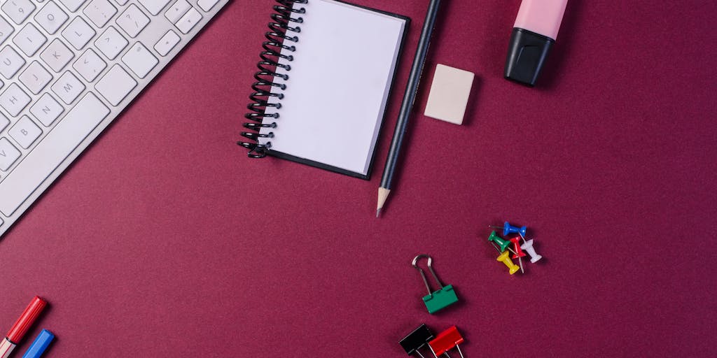Overhead shot of a printed site map laid on a wooden table with colored pushpins and yarn connecting page cards; several yarn lines are clipped with tiny red flags stamped 'nofollow'. Include a notepad, pencil, and smartphone nearby to suggest planning and auditing internal links in a content strategy session.
