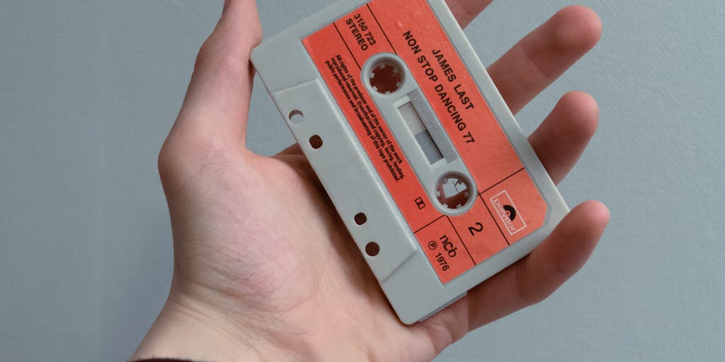 A metaphorical still life: an old-fashioned tape reel or cassette labeled '301' being rewound by a vintage tape rewinder while a printed sitemap and a stack of URL index cards sit nearby; light streaks imply time reversal and restoration of previous routes. Warm, analog tones with textured film grain to convey the idea of rolling back changes.