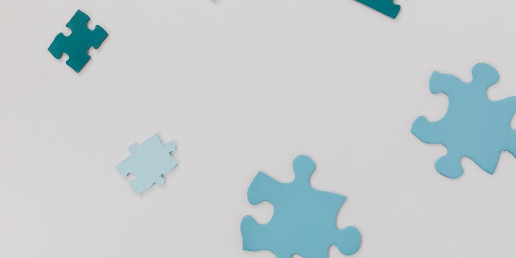 A close-up of a large jigsaw puzzle representing a website, with most pieces interlocking neatly while a single piece labeled “Content” lies separated and face-up on the table. A small printed WordPress logo appears on a nearby piece, and subtle shadows emphasize the gap where the orphaned piece should fit—symbolizing content that isn’t linked into the site structure.