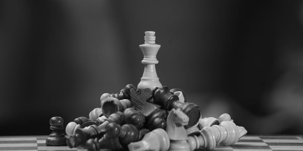An artistic tabletop photo of a chessboard where pieces are replaced with tiny website icons and social/SEO tools; the king piece stands on a miniature search bar podium marked “#1.” Opposing pieces are labeled “competitors” and “algorithms.” Soft directional lighting emphasizes strategy and position, illustrating SEO position meaning as strategic placement in competitive search.